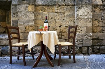 outdoor cafe table with bottle of wine