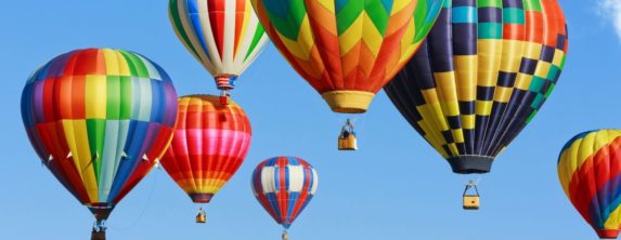 A colorful array of hot air balloons lifting off.