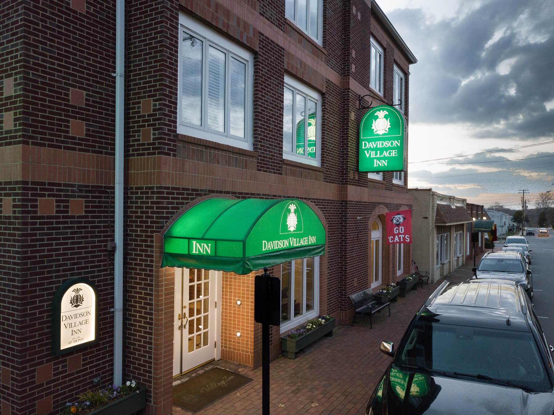 Exterior brick building of Davidson Inn with green awning over entrance