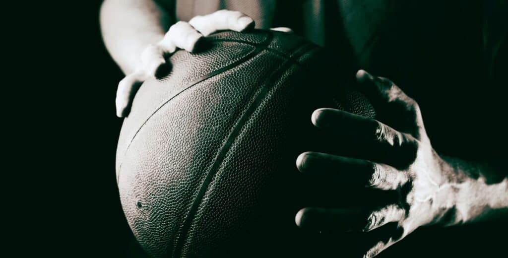 Close-up of a basketball in a player's hands representing Davidson College Wildcats basketball season