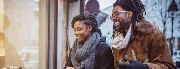 couple smiling while window shopping in the winter