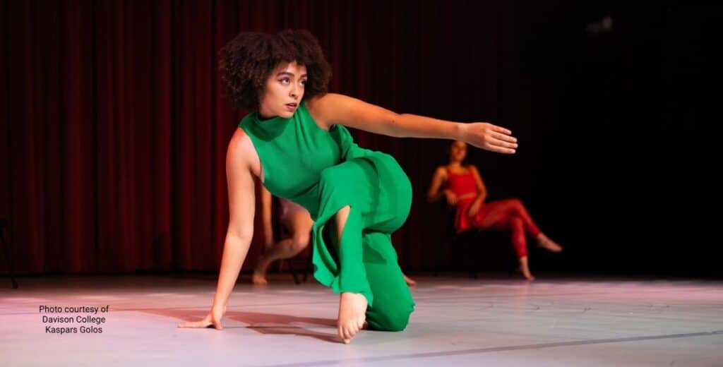 dvi-blog-dancer-in-green | Davidson Village Inn Davidson College dancer in a green outfit performing during a fall dance showcase.
