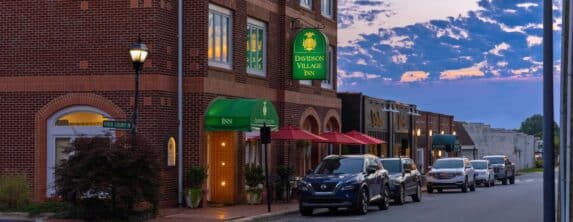 front exterior view at dusk of the davidson village inn with sign lit up