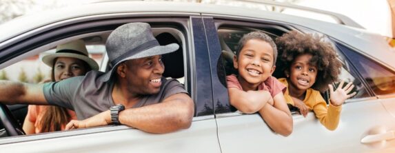 Family enjoying a day trip near Davidson, NC, smiling from a car window during a scenic outing.