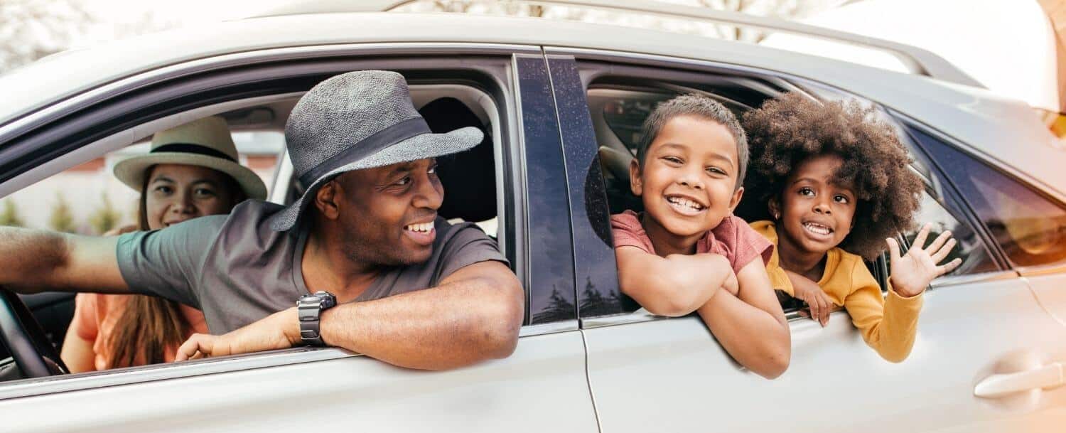 Family enjoying a day trip near Davidson, NC, smiling from a car window during a scenic outing.