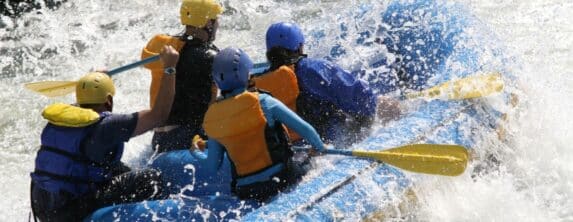 group of people white water rafting in a yellow raft