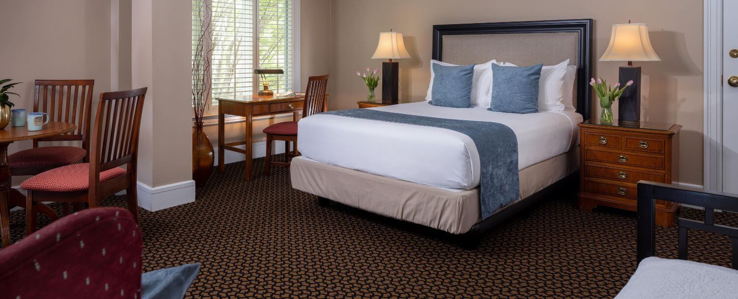 king bed, desk, and sitting area in spacious guestroom at davidson village inn