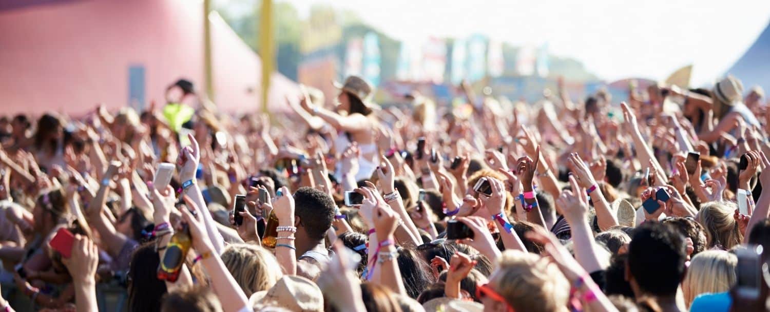 fan crowd cheering at an outdoor music festival