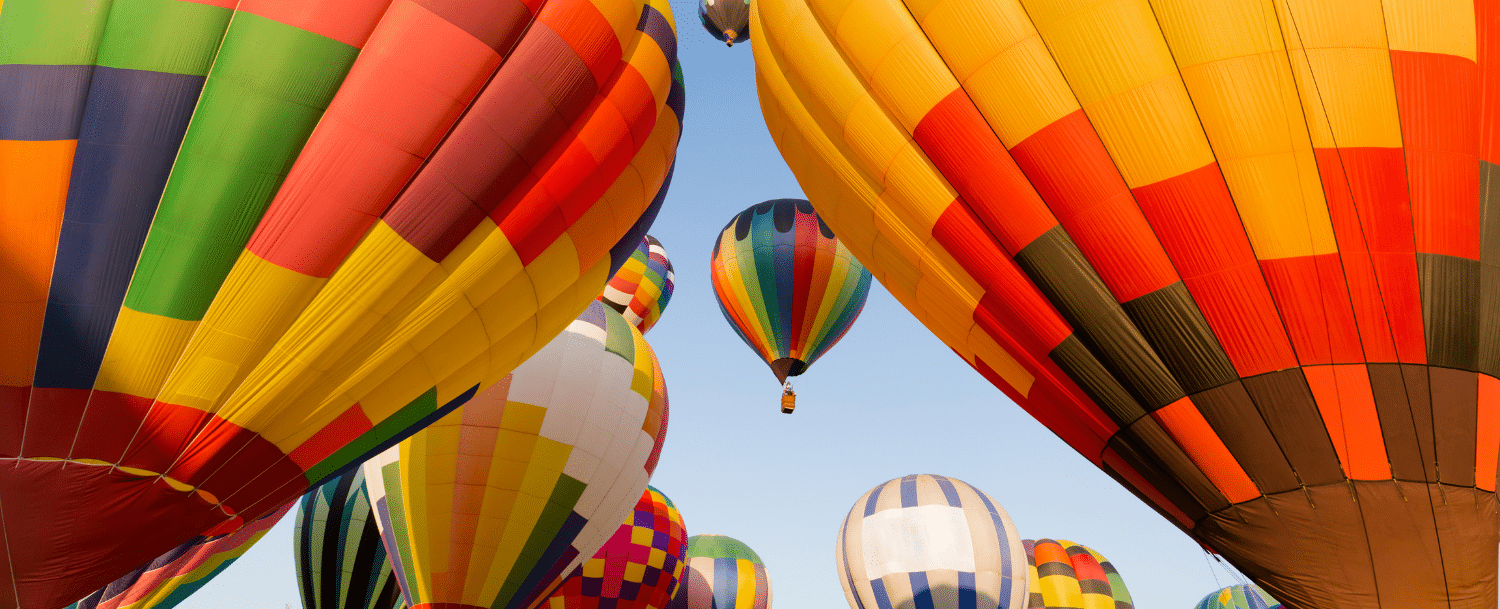 Colorful hot air balloons cluster together at Carolina BalloonFest in Statesville, NC.