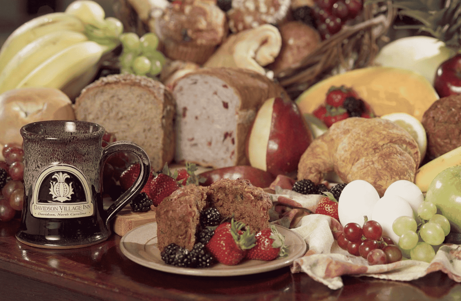 Table topped with a colorful array of breads and fruit for breakfast