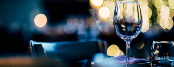 Dining table elegantly set in the evening with wine glasses