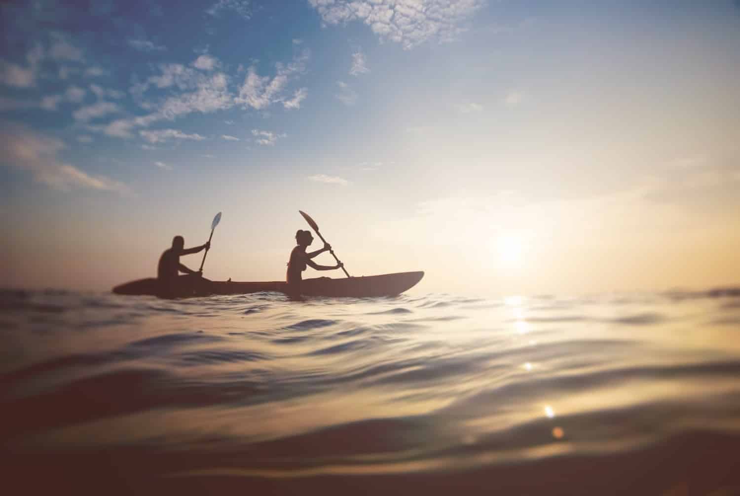 People in a canoe rowing on Lake Norman at sunset