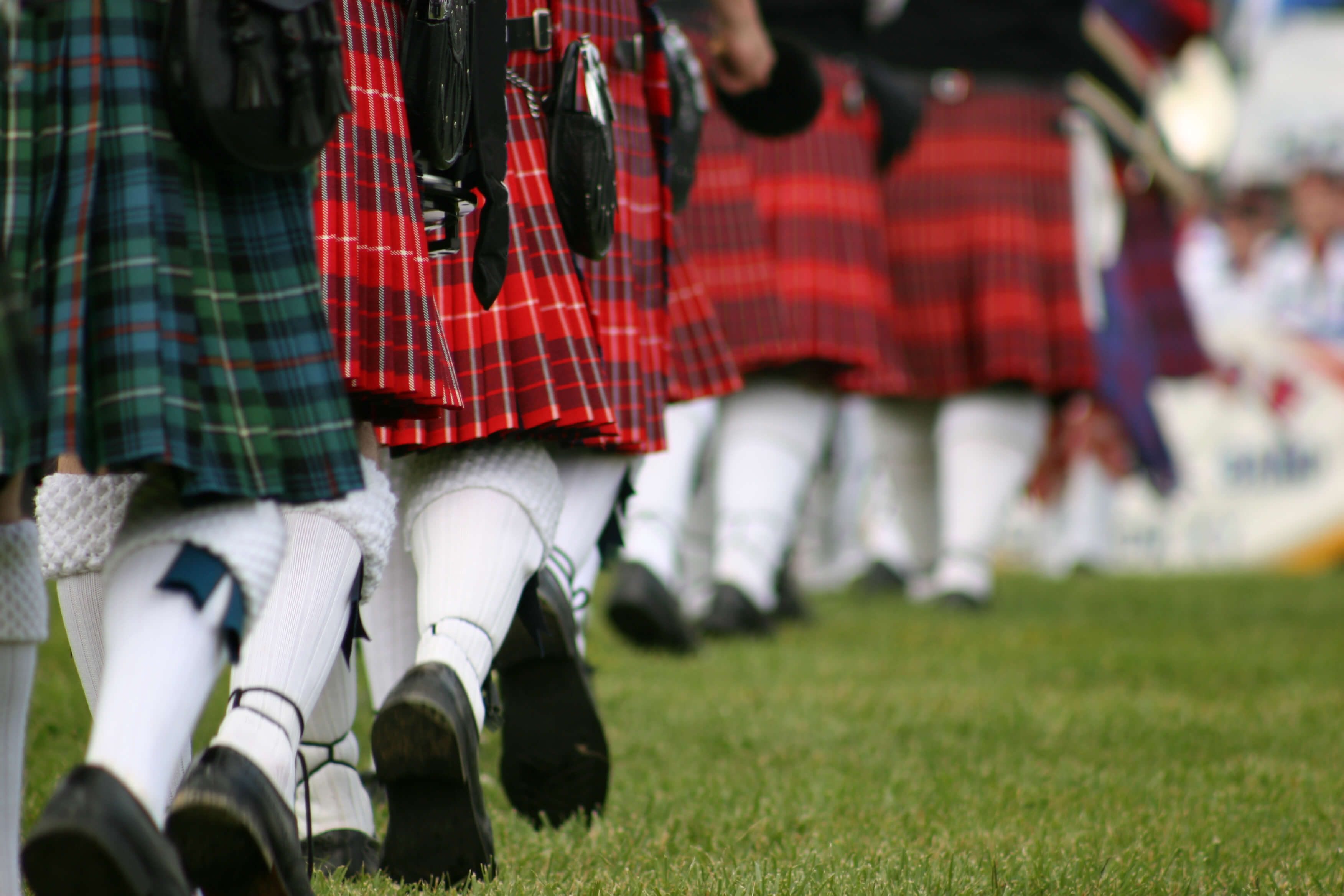 people walking in kilts at event