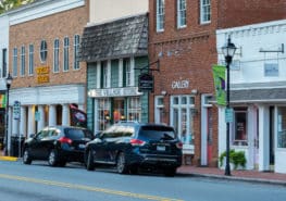Cars parked along street in front of brick stores on Main Street in Davidson, NC