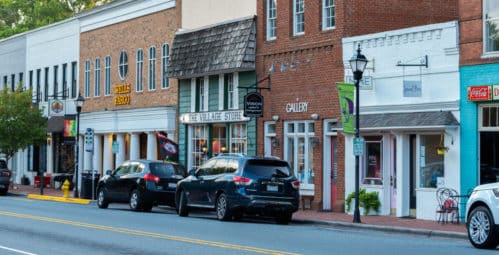 Cars parked along street in front of brick stores on Main Street in Davidson