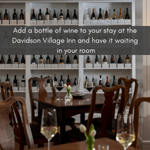 tasting room with walnut tables with glasses of various wines, shelves with a large variety of wines